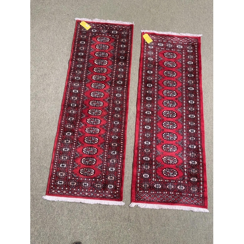 587 - Two Pakistan Bokhara handknotted wool red ground rugs, with central panel of lozenge patterns, and s... 