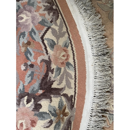 588 - Chinese wash style circular rug  with soft pink and grey floral designs 127cm diameter