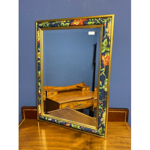 438 - A decorative mirror with hand painted floral and gold coloured border and a framed and glazed moorla... 