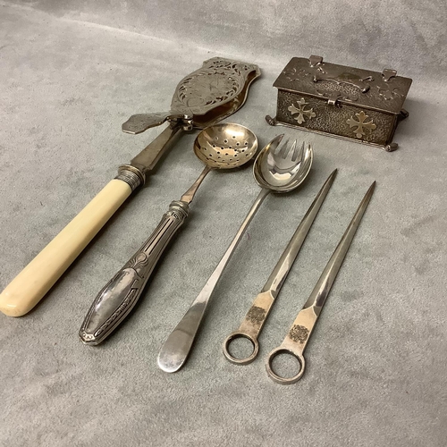 107 - Collection of plated wares to include asparagus tongs and a small white metal casket with applied de... 