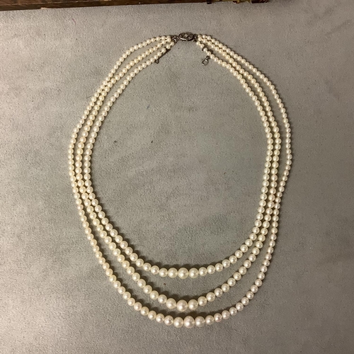 117 - A triple stand of pearls on a diamond set white metal clasp boxed. Largest pearl approx 6mm, approx ... 