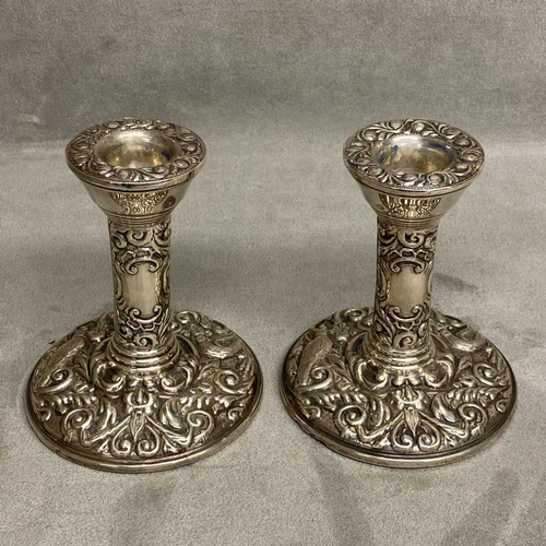 19 - A Pair of Arts and Crafts style sterling silver candlesticks by W J Broadway & Co Birmingham 1924, 1... 