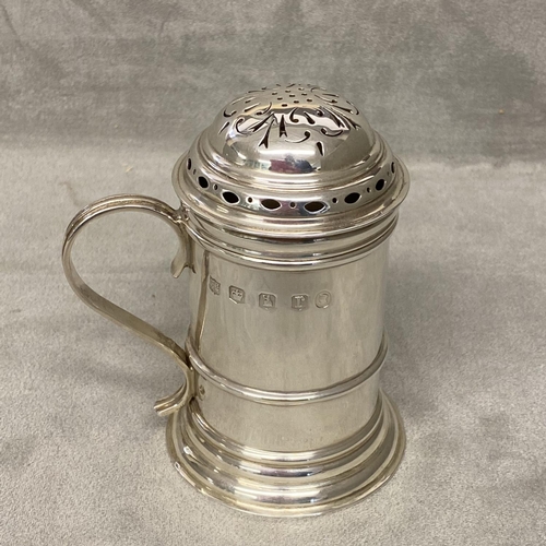 30 - A sterling silver sugar shaker of pillar form with loop handle, Sheffield 1934 by Thomas Bradbury & ... 