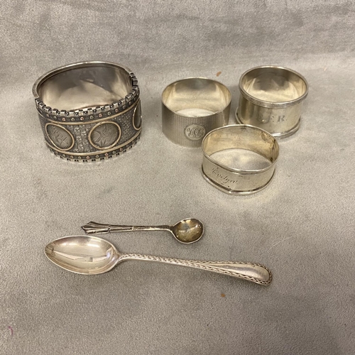 58 - A collection of sterling silver items to include a buckle bracelet, napkin ring and other items