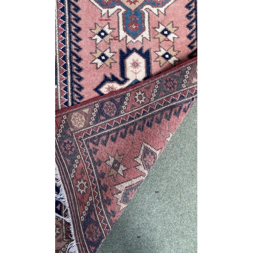 652 - Small oriental rug, pink with blue and cream borders, 126 x 73cm