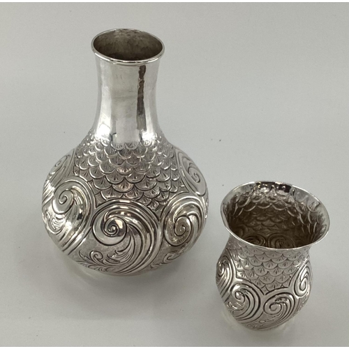 12 - A white metal baluster shaped water flask with swirling and chased decoration, matching goblet, mark... 