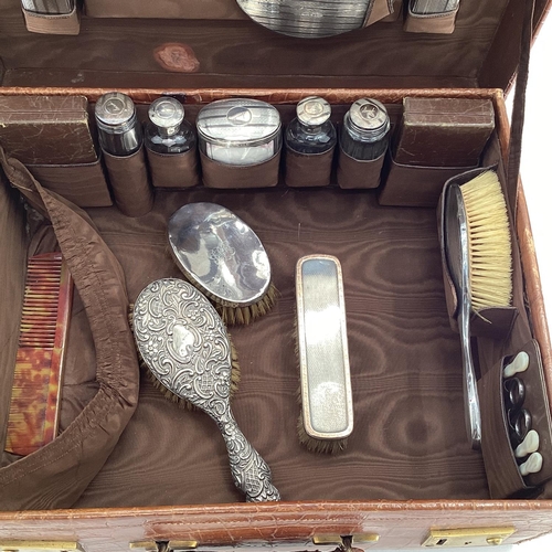 138 - Early C20th crocodile skin ladies travel vanity case, with near complete fitted sterling silver topp... 