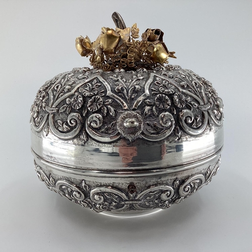 18 - A white metal middle eastern style , circular casket with raised floral decoration, gilt floral fini... 