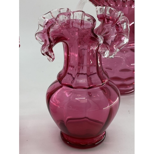 189 - A collection of cranberry glass items to include Jack in a Pulpit vase, lidded bowl, a pair of vases... 