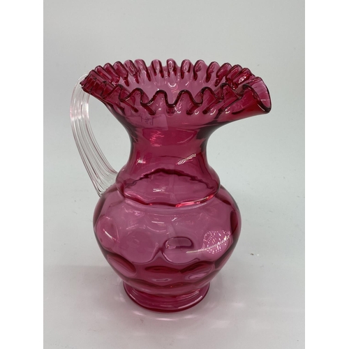 189 - A collection of cranberry glass items to include Jack in a Pulpit vase, lidded bowl, a pair of vases... 