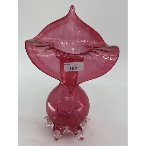 189 - A collection of cranberry glass items to include Jack in a Pulpit vase, lidded bowl, a pair of vases... 