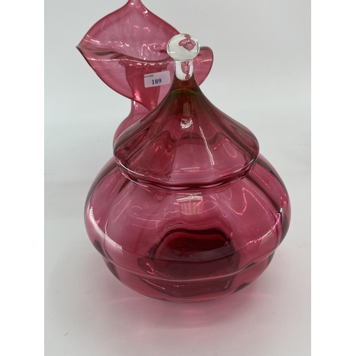 189 - A collection of cranberry glass items to include Jack in a Pulpit vase, lidded bowl, a pair of vases... 