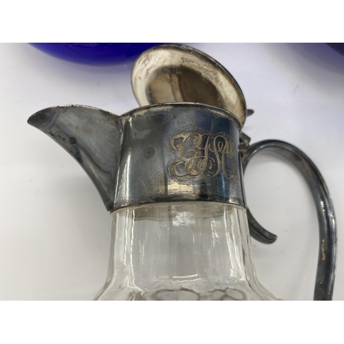 246 - A Stirling silver topped wine carafe together with a white metal topped glass claret jugs, and other... 