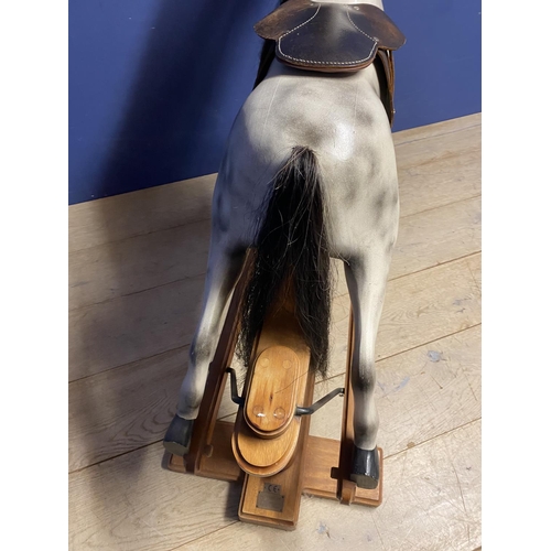 257 - A C20th Rocking horse, grey dappled, on a swing base, and  bears label Horse Play, Broad Hempston, D... 