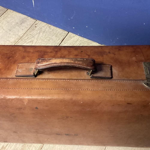 283 - Large leather suitcase and a worn basket ware trunk