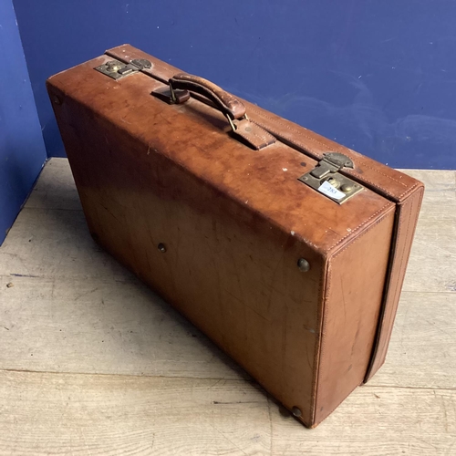 283 - Large leather suitcase and a worn basket ware trunk