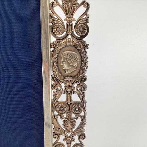 30 - A solid silver pierced easel backed picture frame with cast classical busts and roundels, 30 x 25cm