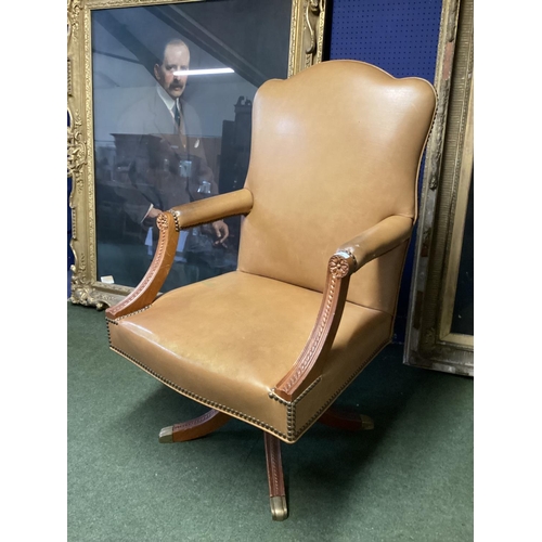 496 - Large winged back light tan and studded brass leather arm chair, on 4 legs to castors