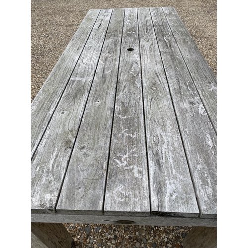 501 - A good solid heavy rustic teak garden plank top table., with parasol hole, general wear and some wea... 