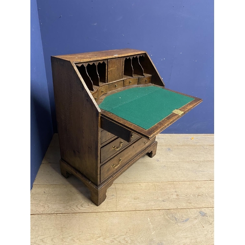 513 - A small George III oak bureau, with four drawers below a fall flap opening to reveal fitted interior