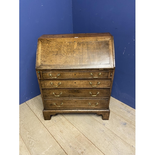 513 - A small George III oak bureau, with four drawers below a fall flap opening to reveal fitted interior