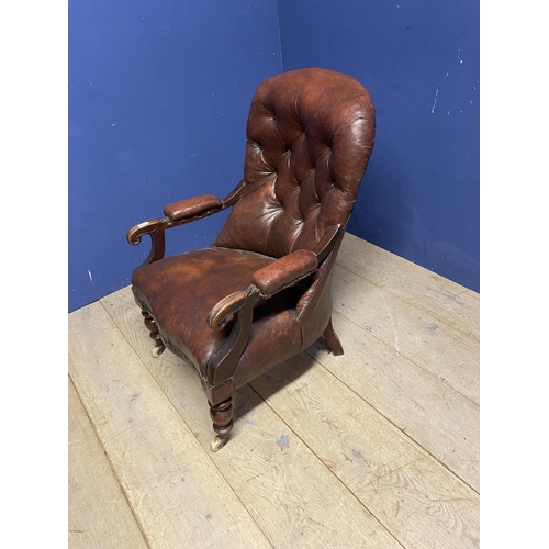 544 - Victorian button back fireside library chair with original rexine or leatheretteupholstery, on turne... 