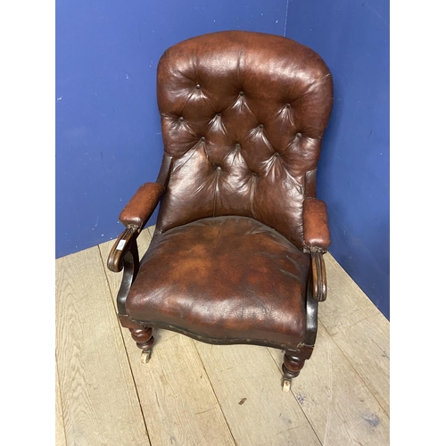 544 - Victorian button back fireside library chair with original rexine or leatheretteupholstery, on turne... 