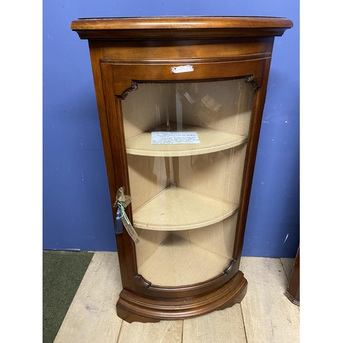 556 - A corner display cabinet with bow front glazed door and key