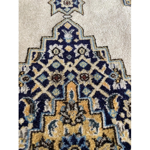 648 - A Qum wool rug, cream and blue ground, 130 x 77cm