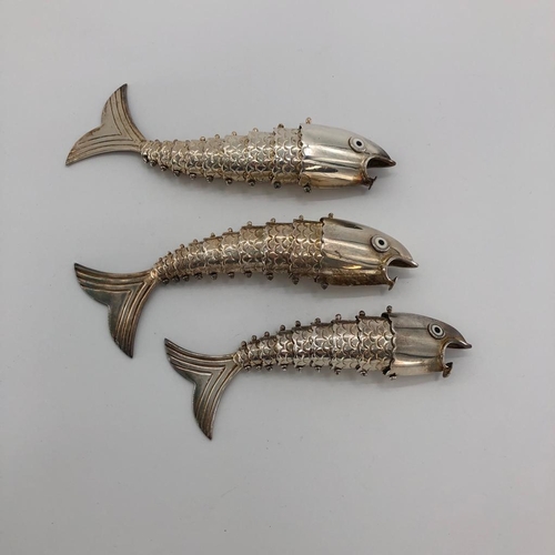 70 - Three graduated white metal articulated fish ornament, with glass enamel eyes marked Mexico, approx ... 