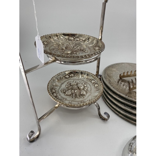 80 - A collection of silver plated items to include coasters, place mats, skewers and other items