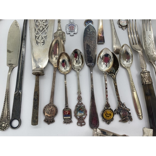 94 - A collection of silver plated and white metal items to include a pair of cast fighting cocks, cutler... 