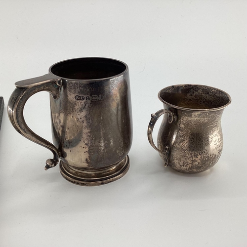 95 - A sterling silver mug, together, together with a silver christening cup and boxed silver handled but... 