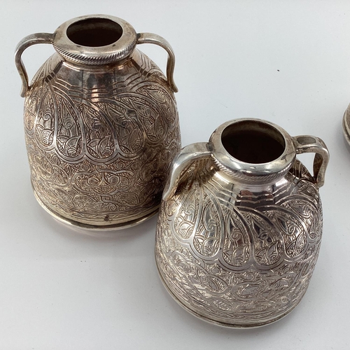 4 - Two pairs of Egyptian white metal decorative water urns, with chased decoration, loop handles and ha... 