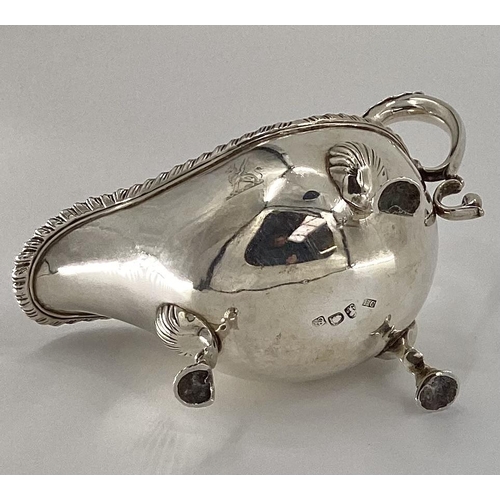 11 - An 18th century sterling silver sauce boat beaded rim, scrolling handle, raised on three feet, by Fr... 