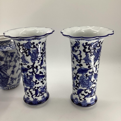 114 - Decorative Modern Blue and White China: a pair of scalloped edge vases, decorated foliage and butter... 