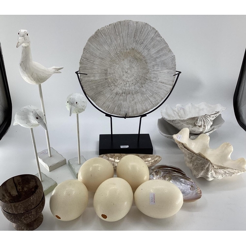 133 - A quantity of decorative items including faux Ostrich eggs, shells, seagull models, fossil type orna... 