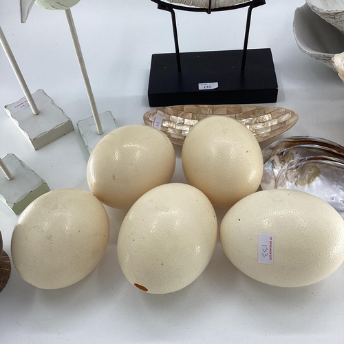 133 - A quantity of decorative items including faux Ostrich eggs, shells, seagull models, fossil type orna... 