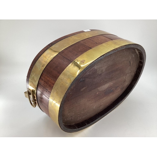 136 - A wooden and brass bound planter with tin interior. Size: oval 60cm x 38 cm x 20 cm height with hand... 