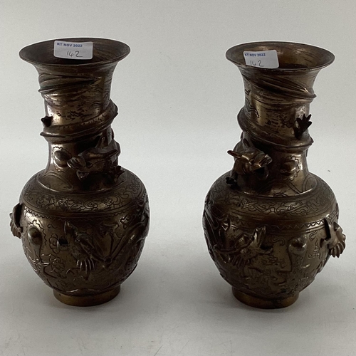 142 - A pair of bronze effect baluster vases, with cast dragon decoration, 25cm high, and a bronze ewer wi... 