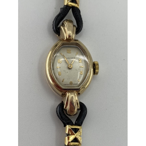 15 - A 9ct gold ladies Longines wristwatch, oval white face, with Baton and number markers on leather str... 