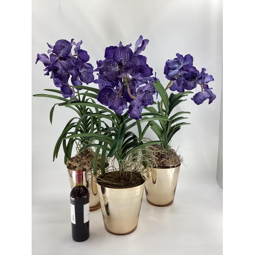 217 - Three  impressive faux flowers, of purple orchid arrangements in glass containers, and mirrored plan... 