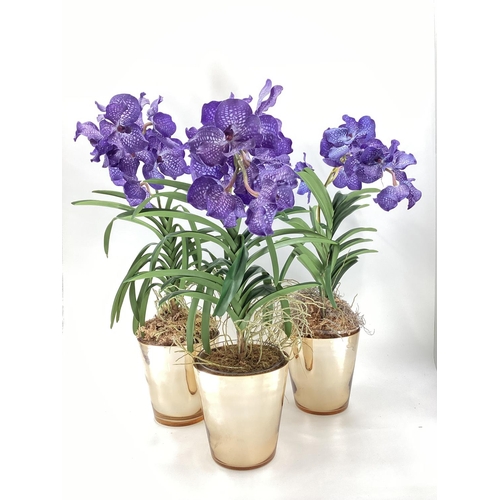 217 - Three  impressive faux flowers, of purple orchid arrangements in glass containers, and mirrored plan... 