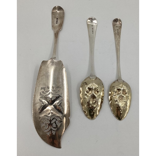 22 - A sterling silver fish slice and two Georgian desert spoons with later applied fruit and berry desig... 