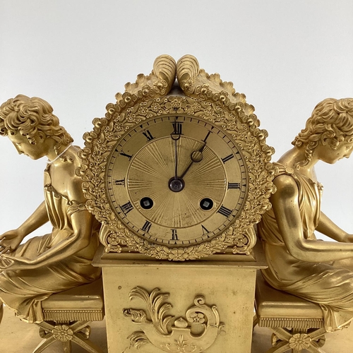 234 - Gilded French mantle clock, flanked by figures of Grecian women sat on Regency style cross stretcher... 