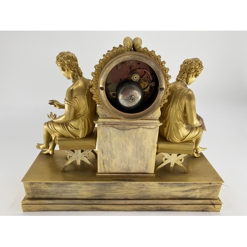 234 - Gilded French mantle clock, flanked by figures of Grecian women sat on Regency style cross stretcher... 