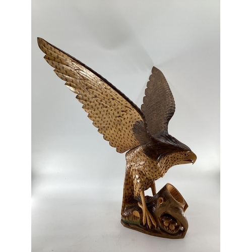 310 - A wooden and resin model of a swooping Eagle on a tree stump (wing detachable) 74 cm x 75 cm x 32 cm