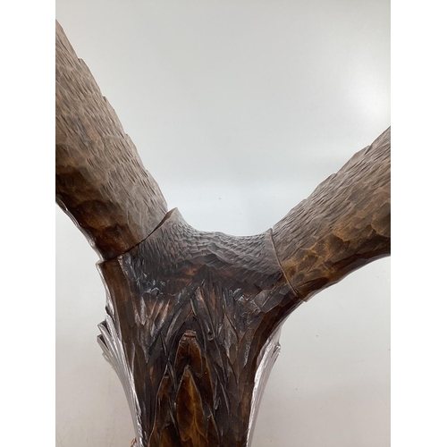 310 - A wooden and resin model of a swooping Eagle on a tree stump (wing detachable) 74 cm x 75 cm x 32 cm