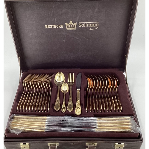 47 - A gilt metal cutlery service, 12 person, by Bestecke Solingen, in fitted leather briefcase  (unused)