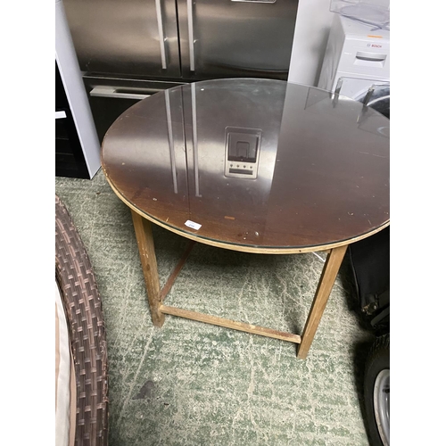 498 - A circular chip board table with glass top (usually used in conjunction with fabric covers); a white... 